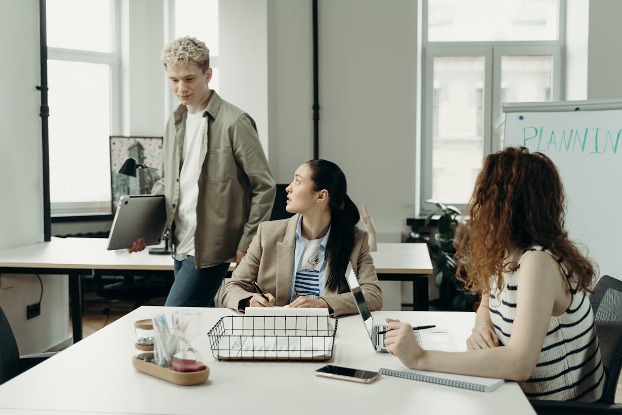 A diverse team of professionals collaborating in a modern office environment, engaged in planning and project development.